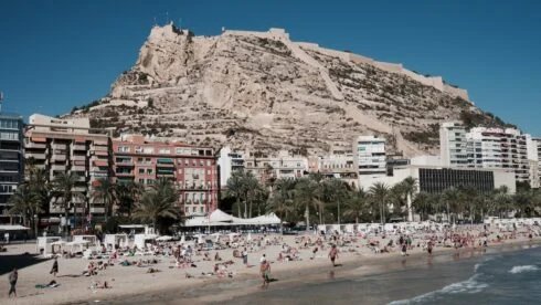 Alicante beach and castle with a mix of foreign and residents on the beach.